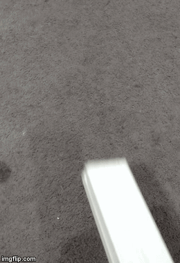 A White Object Is Sitting On A Carpet On The Floor . GIF