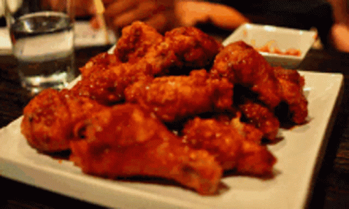 A White Plate Topped With Fried Chicken Wings GIF