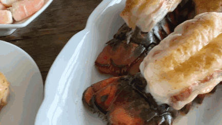 A White Plate Topped With Lobster Tails On A Table GIF