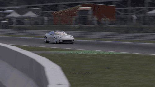 A White Porsche Is Driving Down A Track GIF