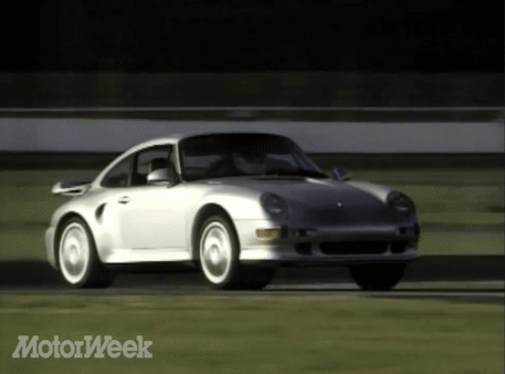 A White Porsche Is Driving On A Track With The Words Motorweek Behind It GIF