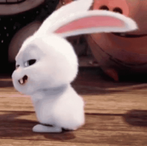 A White Rabbit Is Standing On A Wooden Floor With Its Ears Up . GIF