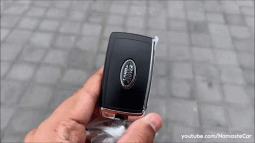 A White Range Rover Velar Is Parked On A Cobblestone Driveway . GIF