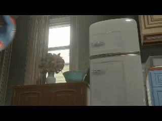 A White Refrigerator Sits In A Kitchen Next To A Vase Of Flowers GIF