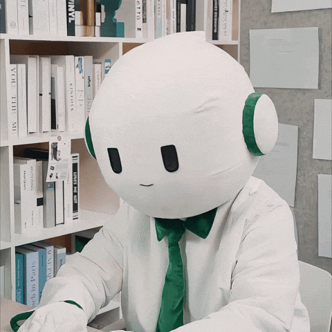 A White Robot With A Green Tie And Headphones Is Sitting In Front Of A Bookshelf With A Book Titled " You The Me " GIF