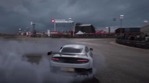 A White Sports Car Is Drifting On A Race Track With A Sign That Says Moscow Festival Next To It GIF