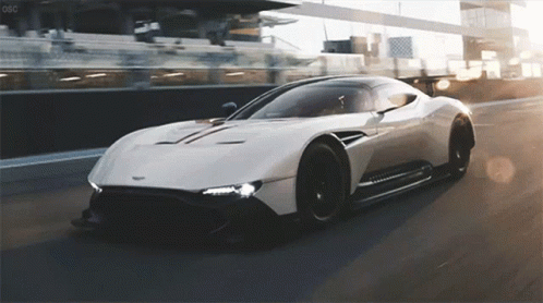 A White Sports Car Is Driving Down A Race Track With The Letters Oso On The Bottom GIF