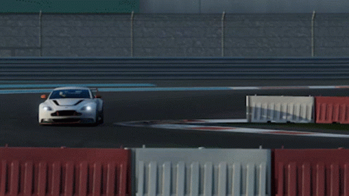 A White Sports Car Is Driving On A Race Track With Other Cars GIF