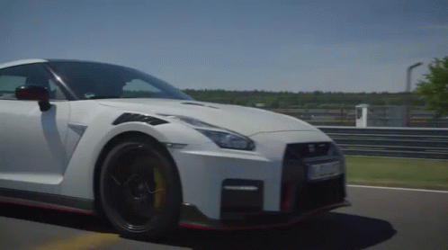 A White Sports Car Is Driving On A Road GIF
