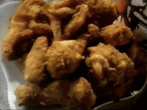A White Styrofoam Container Filled With Fried Chicken GIF