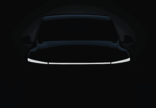 A White Tesla Car With The Word Tesla On The Front GIF