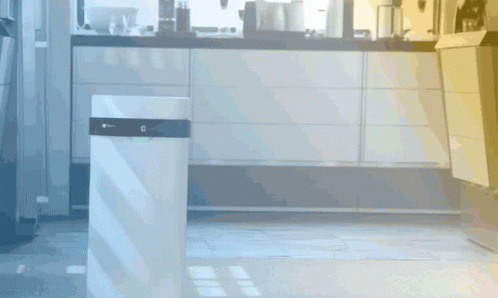 A White Trash Can In A Kitchen With The Letter G On The Top GIF