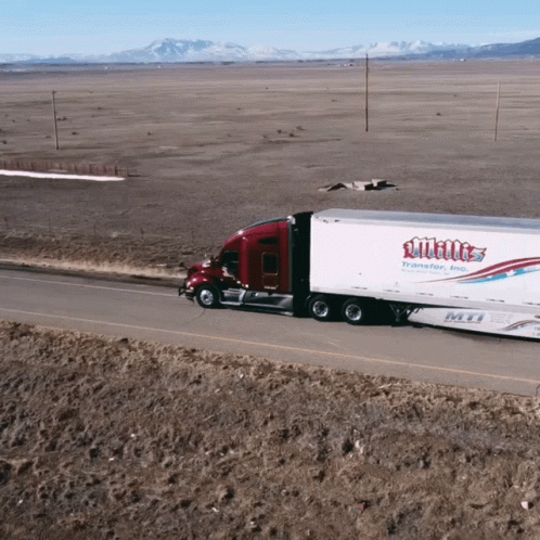 A White Truck Is Driving Down A Desert Road GIF