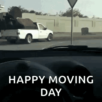 A White Truck Is Driving Down The Road With The Words Happy Moving Day Written On The Bottom GIF