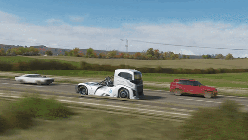 A White Truck With The Word Volvo On The Side Is Driving Down The Road GIF