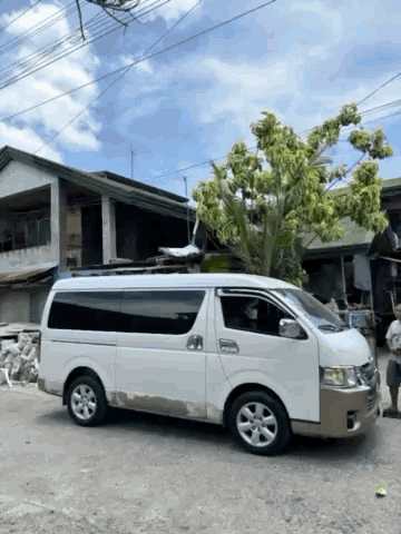 A White Van Is Parked In Front Of A Tree GIF