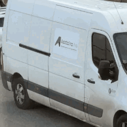 A White Van Is Parked On The Side Of The Road And Has A Sticker On The Side That Says A. GIF