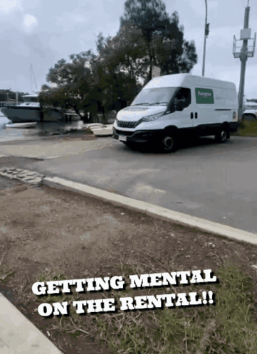 A White Van Is Parked On The Side Of The Road With The Words " Getting Mental On The Rental " Below It GIF