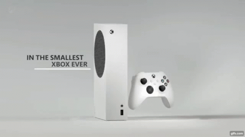A White Xbox Controller Is Sitting Next To A Black Box On A Table . GIF