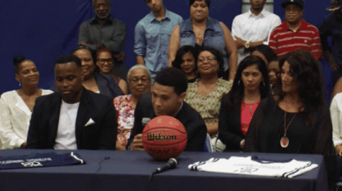 A Wilson Basketball Sits On A Table In Front Of A Crowd GIF