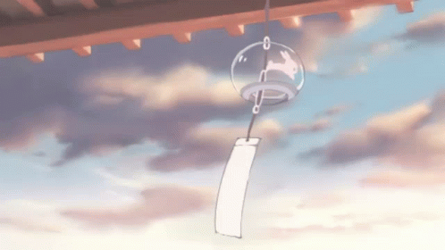 A Wind Chime With A Rabbit On It Is Hanging From The Roof Of A Building GIF