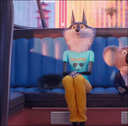 A Wolf Wearing A California Shirt Sits On A Blue Couch GIF