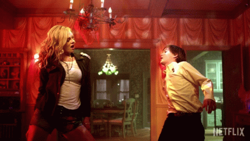 A Woman And A Boy Are Dancing In A Room With A Netflix Logo GIF