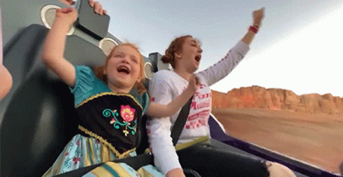 A Woman And A Little Girl Are Riding A Roller Coaster And The Little Girl Is Wearing A Frozen Dress GIF