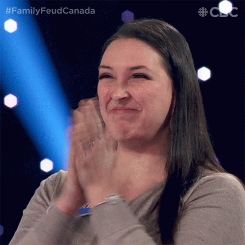 A Woman Applauds While Sitting In Front Of A Screen That Says Family Feud Canada GIF