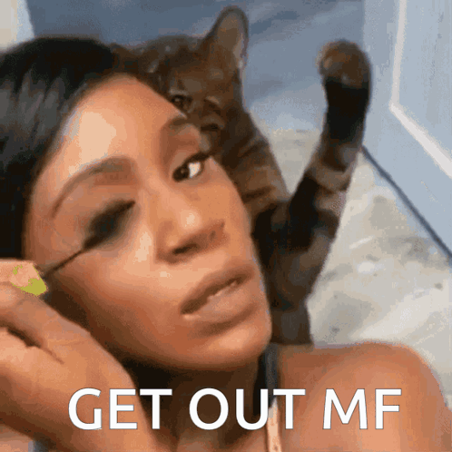 A Woman Applying Mascara With A Cat Behind Her And The Words Get Out Mf On The Bottom GIF