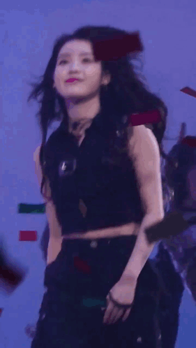 A Woman Blowing A Kiss While Holding A Microphone In Front Of Her Face GIF