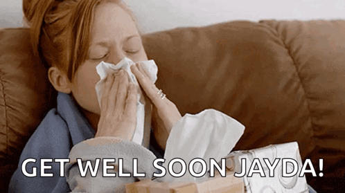 A Woman Blowing Her Nose While Sitting On A Couch With The Words Get Well Soon Jayda Written On The Bottom GIF