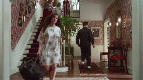 A Woman Carrying A Black Bag Walks Down The Stairs GIF