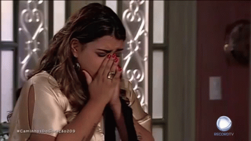 A Woman Covering Her Face While Watching A Recordtv Show GIF