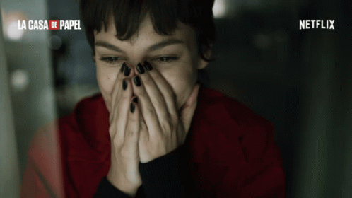 A Woman Covering Her Face With Her Hands And The Words La Casa De Papel Behind Her GIF