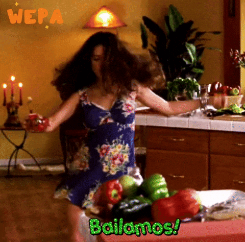 A Woman Dancing In A Kitchen With The Words Bailamos GIF