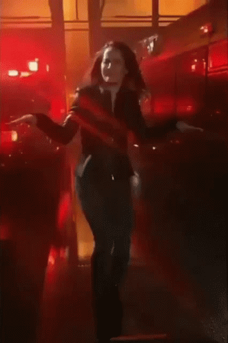 A Woman Dancing In Front Of A Fire Truck GIF