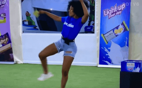 A Woman Dancing In Front Of A Light Up Your Day Advertisement GIF