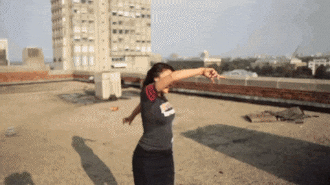 A Woman Dancing On A Rooftop Wearing A Shirt That Says ' Chicago ' On It GIF
