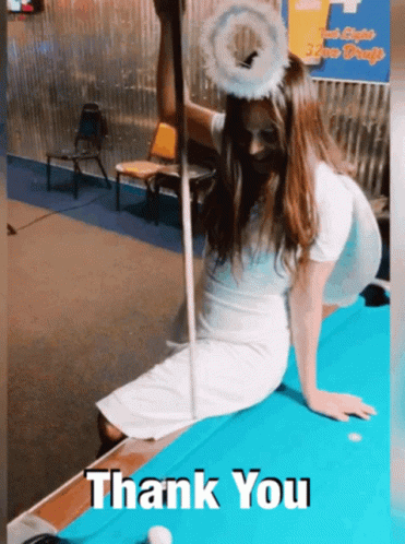 A Woman Dressed As An Angel Is Sitting On A Pool Table With The Words Thank You Written Below Her GIF