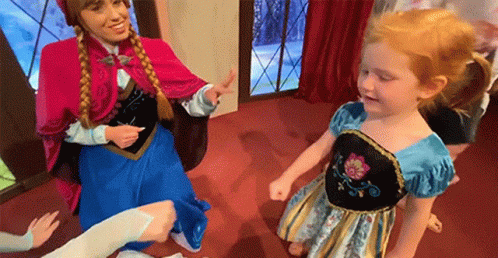 A Woman Dressed As Anna And A Little Girl Dressed As Elsa Are Dancing Together . GIF