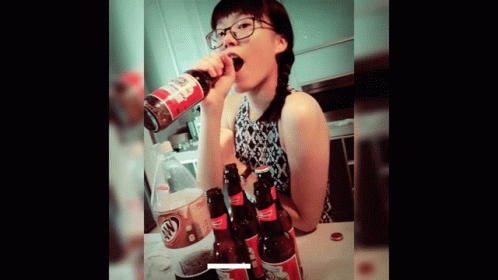 a woman drinking a bottle of root beer from a can