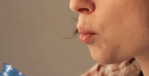 A Woman Drinking From A Blue Cup With Her Mouth Open GIF
