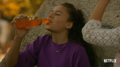 A Woman Drinking From A Bottle With A Netflix Logo On The Bottom GIF