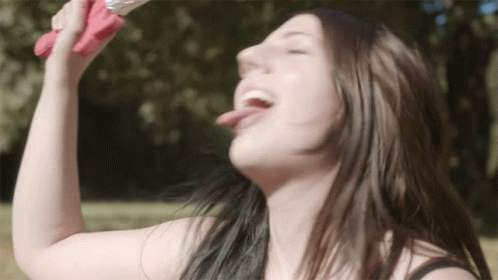 A Woman Drinking From A Pink Bottle With Her Tongue Sticking Out GIF