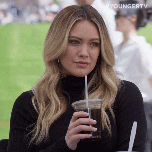 a woman drinking from a plastic cup with a straw and the words youngertv on the bottom