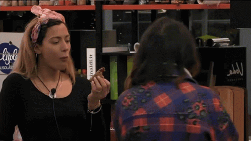 Woman Eating Food In Front Of L'isola Sign GIF
