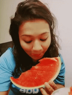 A Woman Eating A Slice Of Watermelon Wearing A Shirt That Says App GIF