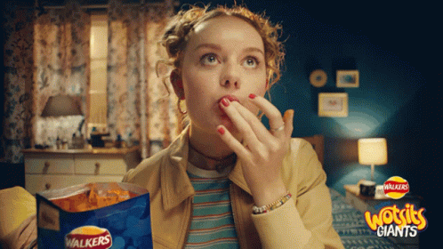 A Woman Eating Walkers Giants Chips In A Room GIF