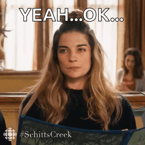 A Woman From Schitts Creek Is Holding A Blue Scarf GIF